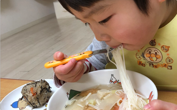 子供が麺を食べている様子