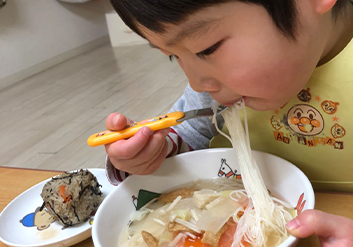 子供が麺を食べている様子