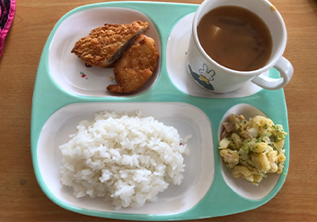 プレートにご飯、おかず、スープがのっている